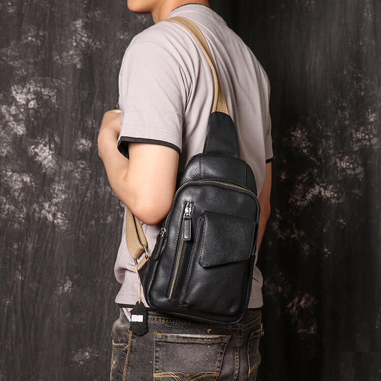 Black leather sling bag worn over the shoulder, side view